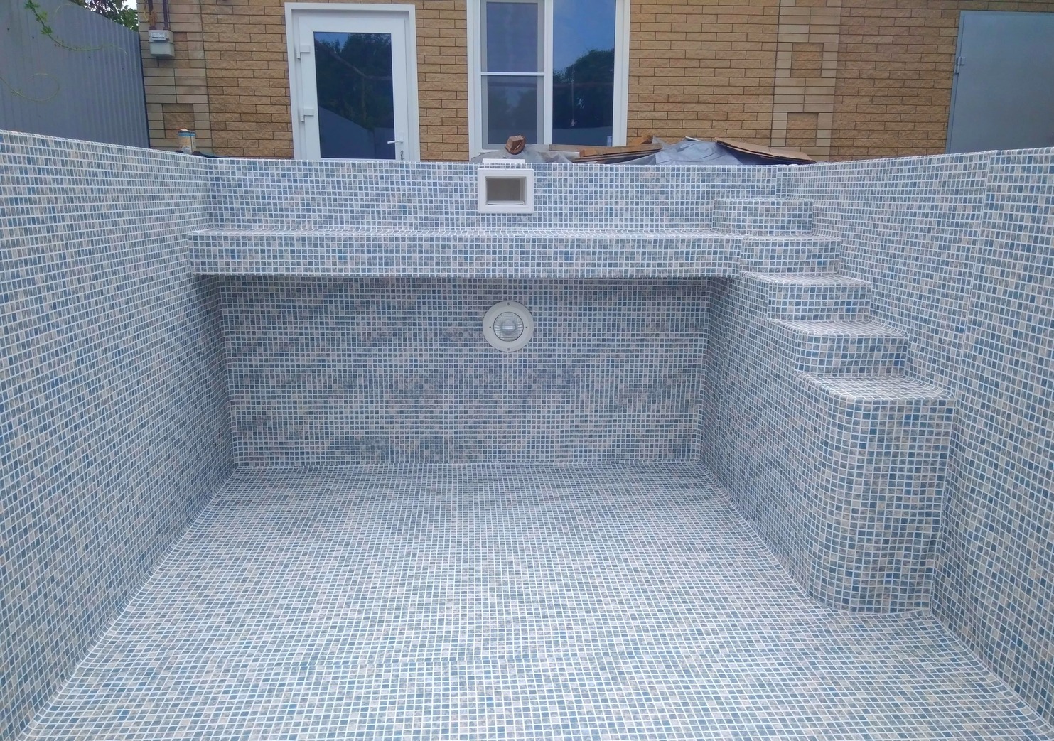 Построенный бассейн с бетонной чашей, отделанный плиткой
