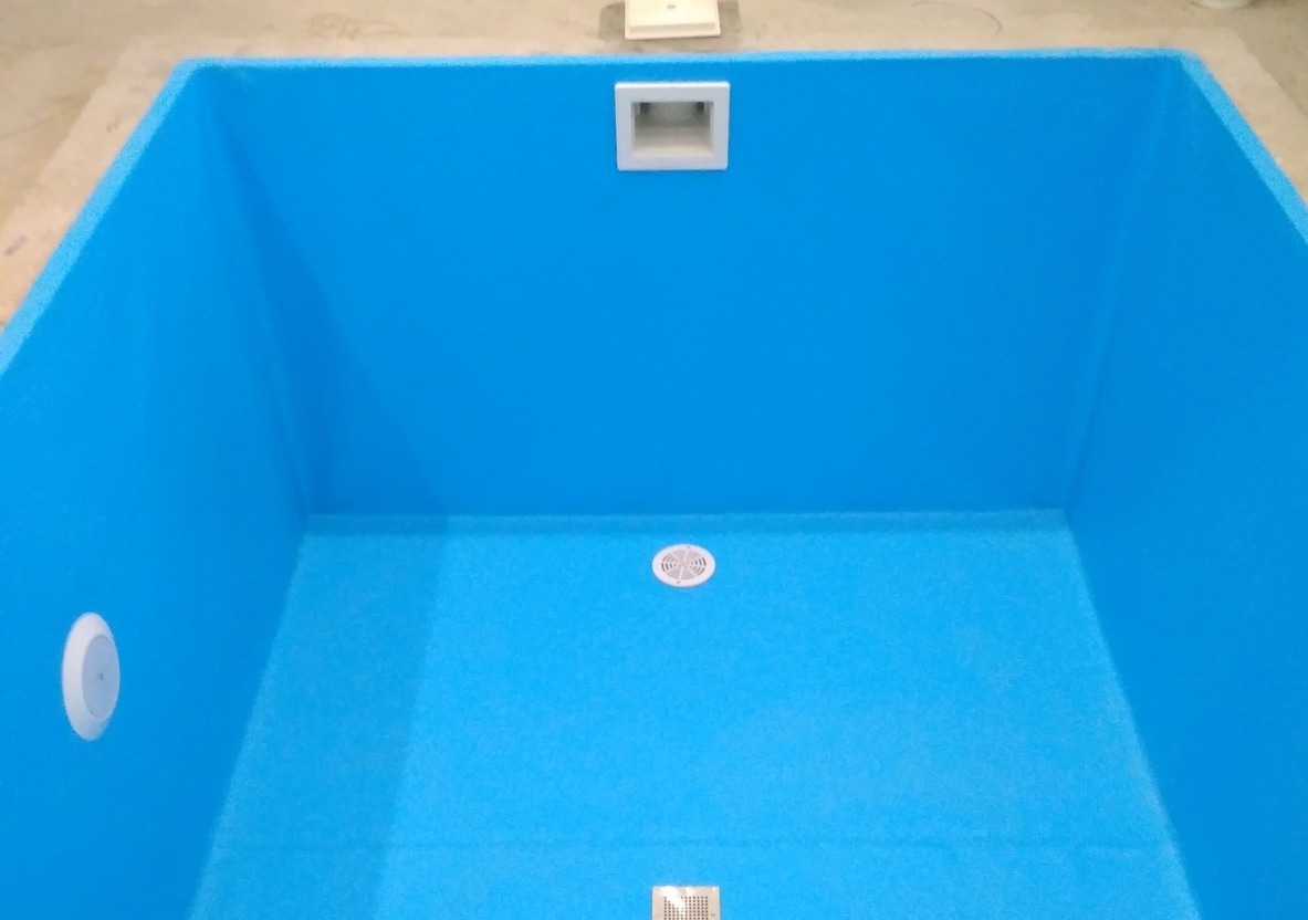 Устроенный бетонный бассейн с голубой отделкой
